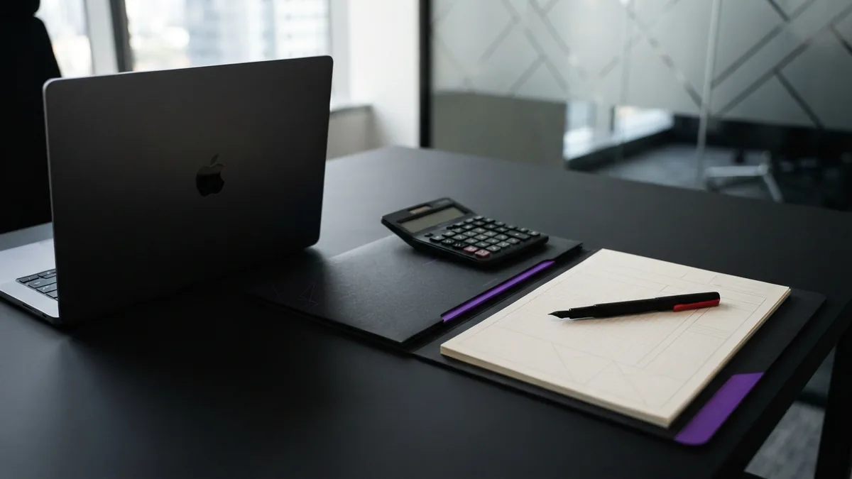 Calculator, tax forms, and business records arranged on a clean office desk